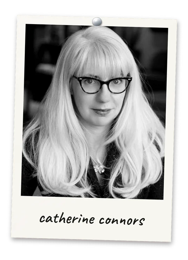 Black-and-white Polaroid photograph of co-host Catherine Connors wearing glasses, pinned at the top with a handwritten caption reading catherine connors.